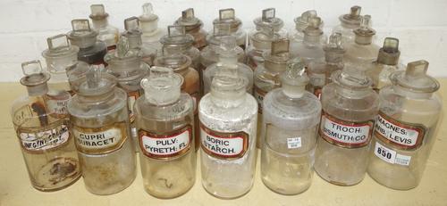 Twenty eight glass apothecary jars and stoppers, 20th century, each with recessed gilt label (a.f), 19cm high. (28)