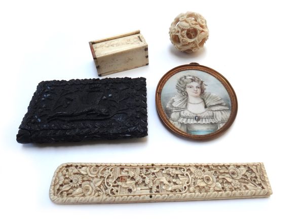 An Irish bog oak visiting card case, relief carved with hounds, harps and clover, 12cm long, a portrait miniature on ivory, a Chinese carved ivory bal
