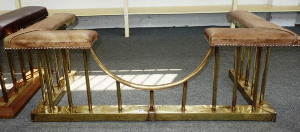A brass and leather club fender, 20th century, with plain pillared rails and studded detail to the leather, 140cm wide.