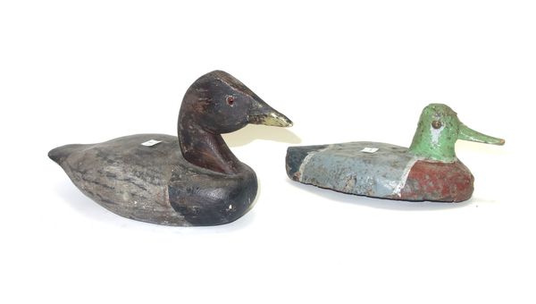 A polychrome painted wooden decoy duck, 19th century, with lead weight beneath, 26cm long, and seven other painted wooden decoy ducks. (8)