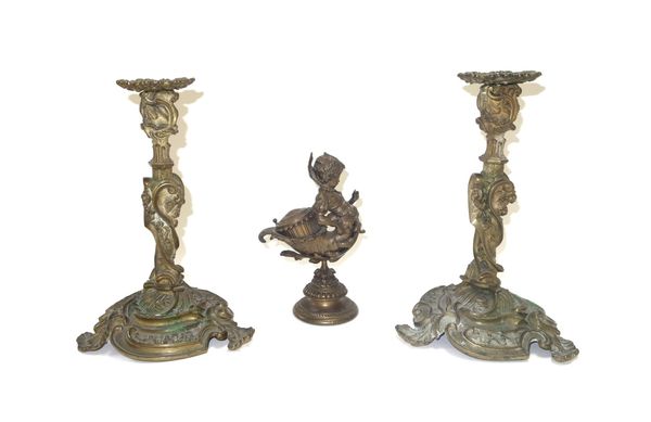 A pair of Rococo style gilt bronze candlesticks, 19th century, raised on three foliate scroll feet, 27cm high, together with a bronze figural inkwell,