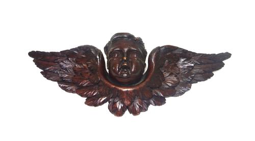 An 18th century figural carved oak corbel, 39cm wide, a 19th century carved cherub, a 19th century foliate carved oak panel, 41cm x 24cm, an oak wall