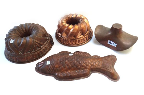 Three Continental copper jelly moulds, circa 1900, of circular moulded form 29cm diameter, a later copper 'fish' jelly mould and a similar shaped copp