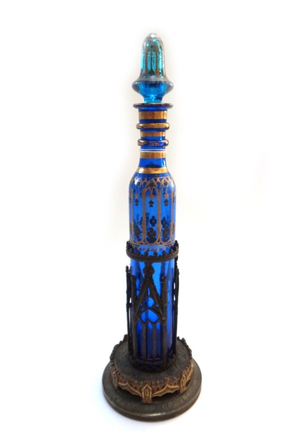 A Bohemian gilt blue glass scent bottle and stopper, early 20th century enclosed in a gilt brass Gothic stand, bottle 31cm high; a patinated bronze bu