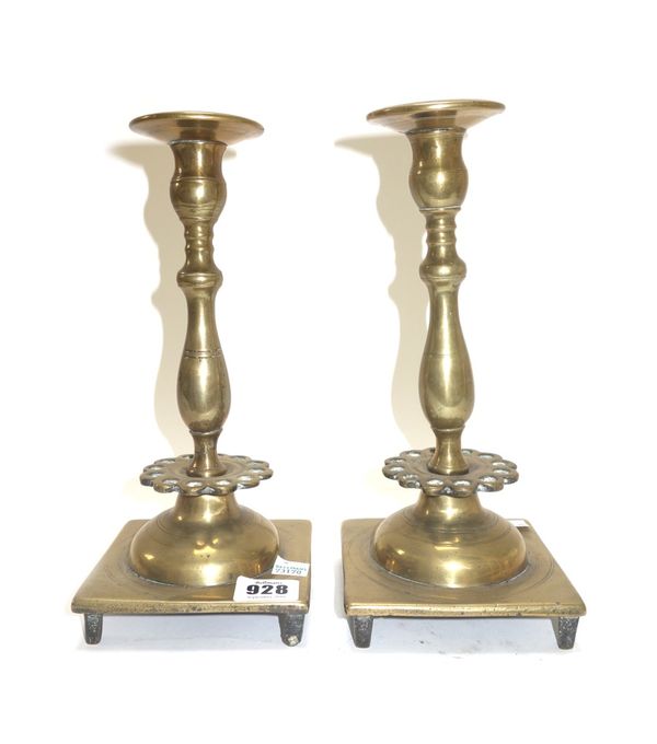 A pair of 18th century bronze candlesticks with a pierced collar 25cm high, an English brass candlestick circa 1710 with octagonal foot and stem 14cm
