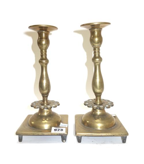 A pair of 18th century bronze candlesticks with a pierced collar 25cm high, an English brass candlestick circa 1710 with octagonal foot and stem 14cm