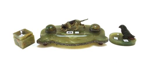 An onyx desk compendium, circa 1920, the twin inkwells with domed hinged lids flanking an Austrian cold painted bronze hound, with a shaped pen recess