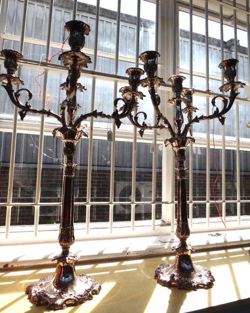 A pair of Louis XVI style silver plated five branch candelabra, modern, of foliate scroll form, with fluted column and shaped foliate cast base, 72cm