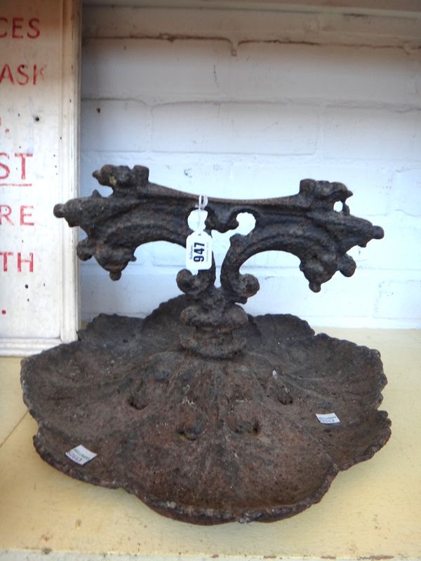 A Victorian cast iron boot scraper with a foliate pierced base, 37cm wide, together with a Victorian cast iron half block door stop with loop handle,