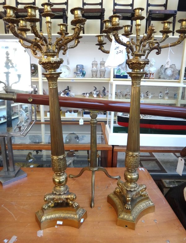 A pair of gilt bronze Empire style eight branch candelabra, 20th century, each foliate scroll arm over a fluted tapering column, three lions paw feet