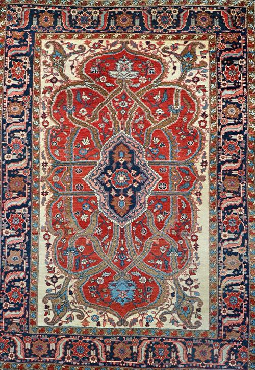 A Heriz carpet, Persian, the shaped madder field with an indigo medallion, brown ribbon design; with ivory spandrels; an indigo flowerhead, leaf and v