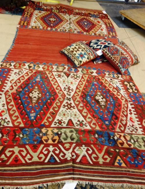 A South Persian kelim, a plain madder central band with hooked diamond panel to each end, 320 x 148cm and three kelim cushions. (4).