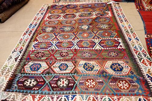 A Turkish kelim, banded design of hexagonal medallions 250 x 192cm and a cut rug with three diamonds. (2).