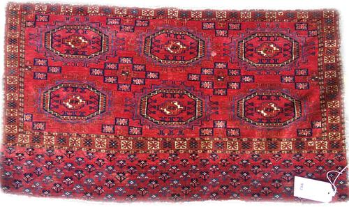 A Salor Juval, the madder field with two rows of three guls, supporting stepped crosses, a plant skirt and sunburst border, skirt end, 64cm x 112cm.