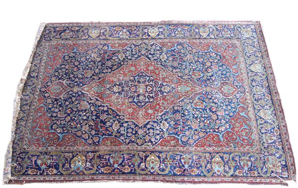 An Isfahan rug, Persian, the indigo field with a madder medallion and spandrels, all with floral vines, an indigo palmette, ribbon and floral spray bo