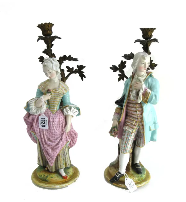 A pair of porcelain and gilt bronze figural candlesticks, late 19th century, modelled as gallant and companion, on circular stepped bases, 41cm high (