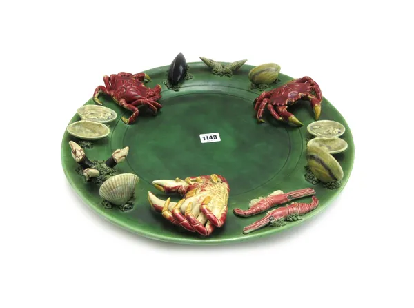 A Portuguese pottery wall plate, 20th century, decorated to the wide border with applied crabs, mussels, clams and shells against a green ground, impr
