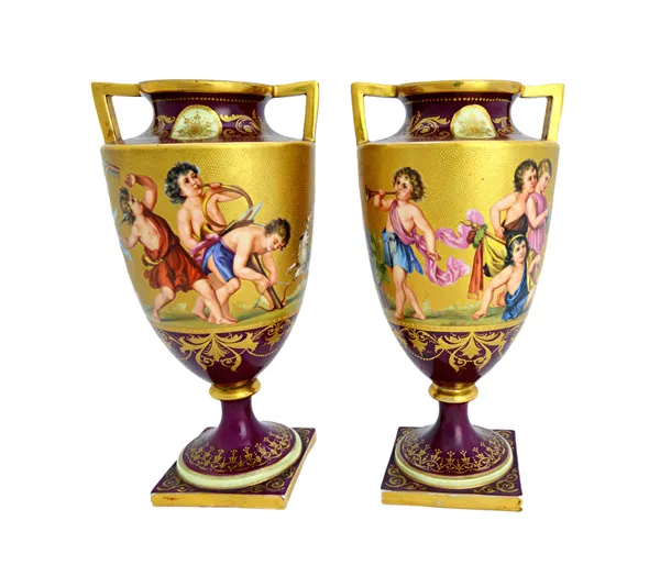 A pair of Vienna style porcelain vases of twin handled urn form, late 19th/early 20th century, each decorated with a gilt band of classical child figu