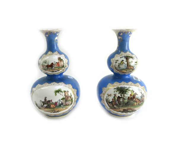 A pair of Dresden porcelain vases, early 20th century, each of double gourd form, decorated with hunting scenes against a gilt blue ground, 'AR' mark