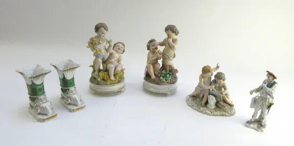 Two Continental porcelain figure groups, each modelled with putti on a circular base, 21.5cm high, a Berlin porcelain putti group, a Sitzendorf strut