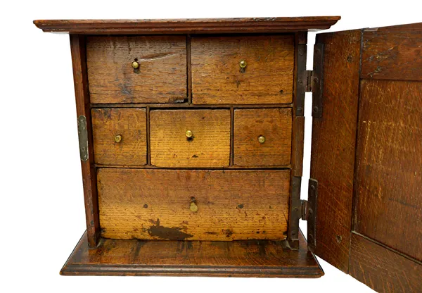 An 18th century oak spice cupboard, the deep fielded door enclosing six drawers, 40cm wide x 36cm high.   Illustrated