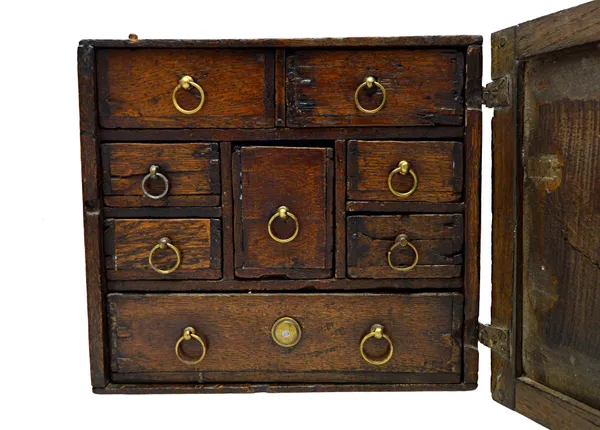 An 18th century oak spice cupboard, the single door enclosing eight drawers, 26cm wide x 16cm deep.   Illustrated