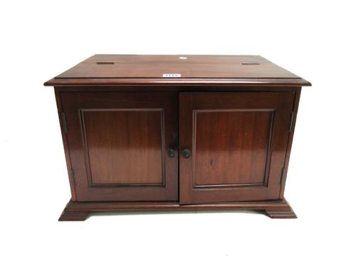 A 19th century mahogany table top cabinet, with lift top and pair of doors, on pointed bracket feet, 46cm wide x 31cm deep.