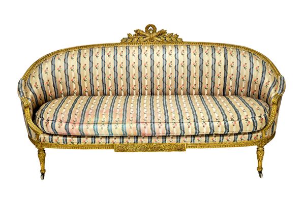 A Louis XVI cream painted tub back sofa, with torch and quiver carved crest on fluted supports, 216cm wide x 112cm high.    Illustrated