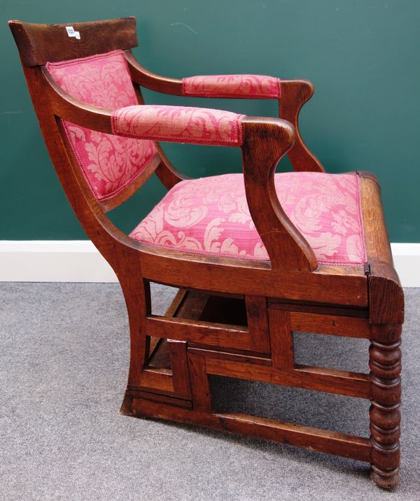 A mid-19th century oak metamorphic library chair on turned supports, 60cm wide x 85cm high.