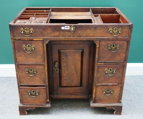 A George II mahogany knee hole dressing table, with fitted interior over cupboard and six drawers, the top lacking, 21cm wide x 52cm deep.