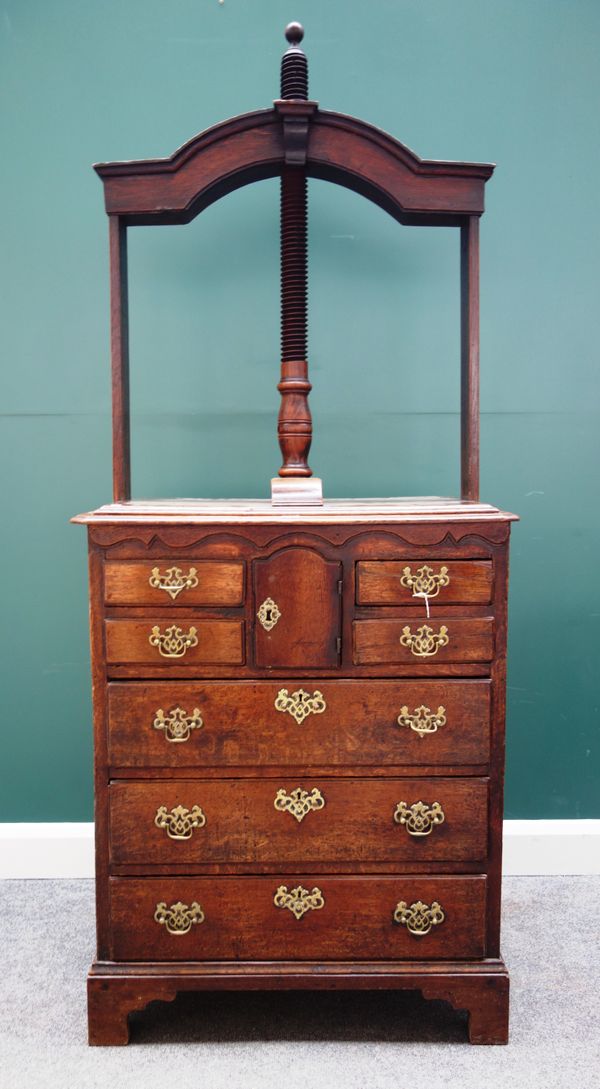 An 18th century oak book press chest, the screw top over a single cupboard, and four short and three long drawers, 82cm wide x 200cm high.