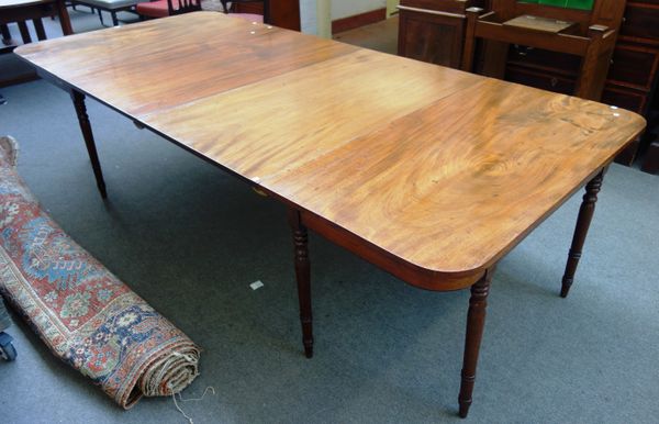 A George III mahogany extending dining table, with a pair of rounded 'D' end sections and two extra leaves, on turned supports, 130cm wide x 136cm lon