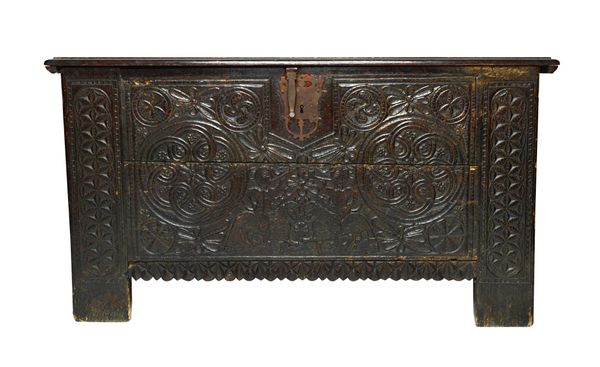 A large 17th century and later Spanish chest, the plank top over a carved front decorated with opposing figures playing horns on horseback, over a sha