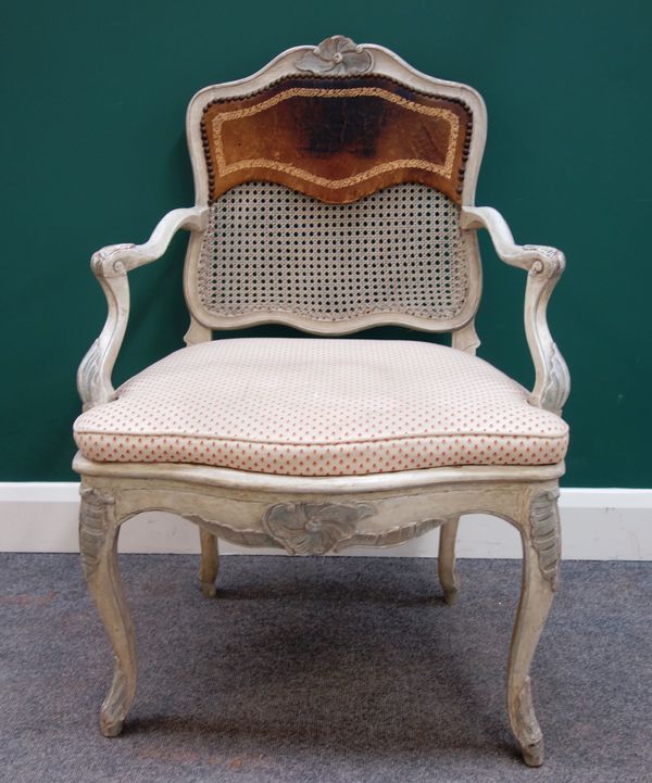 A Louis XV cream painted open arm fauteuil on scroll supports, 70cm wide x 98cm high.