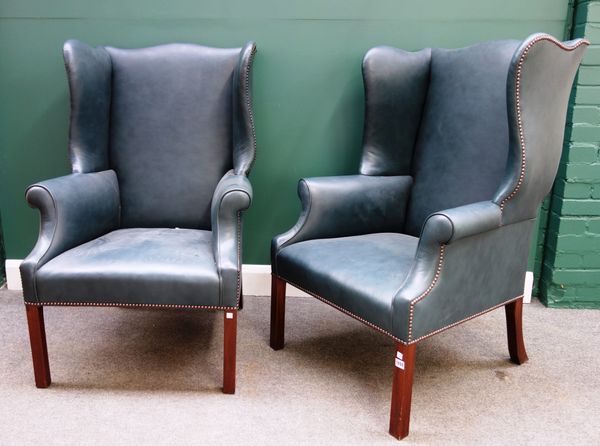 A pair of George II style blue leather upholstered wingback armchairs, on square supports, each 75m wide x 112cm high, (2).