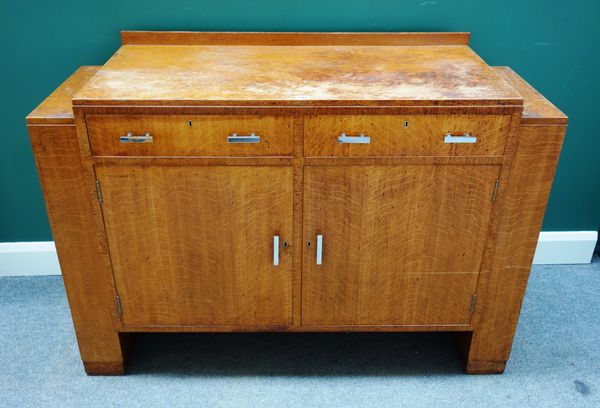 Heals; an oak sideboard, with pair of drawers over cupboards flanked by lift top compartments, ivorine disk, 132cm wide x 51cm deep.