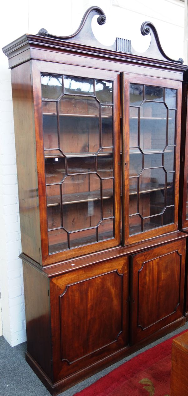 A George III later adapted mahogany bookcase cupboard, the pair of astral glaze doors over cupboards enclosing drawer, 147cm wide x 260cm high.