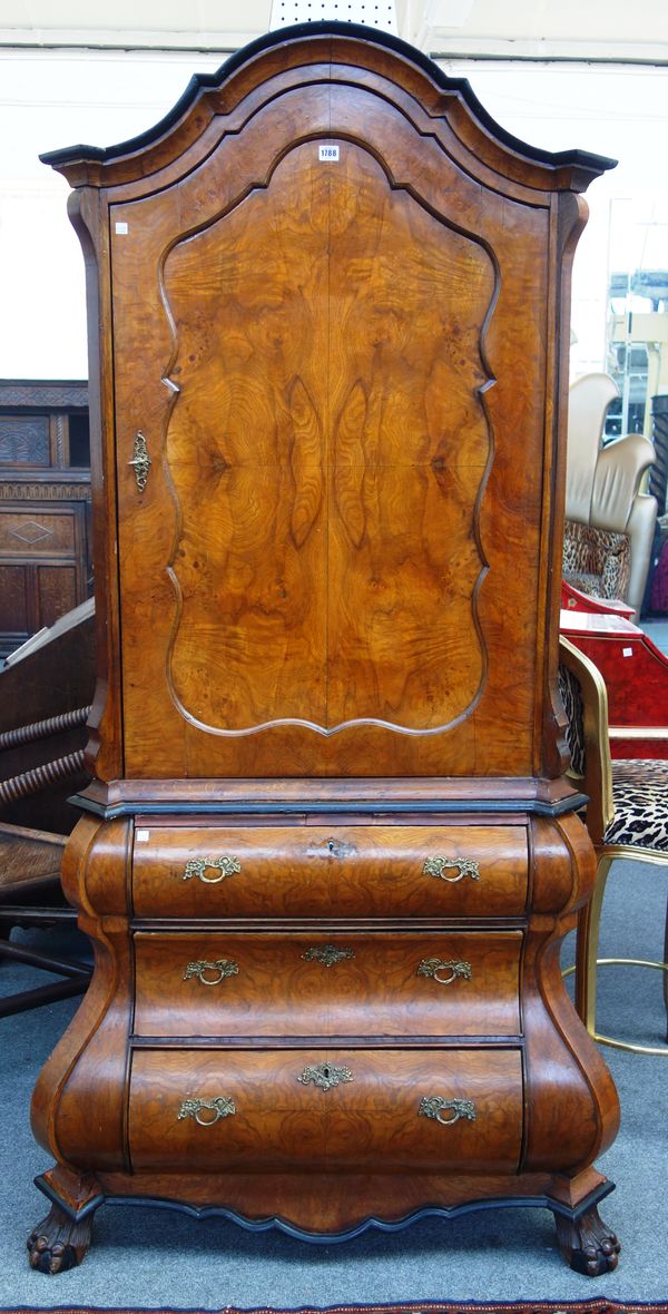 A 19th century Dutch figured walnut bureau cabinet, with shaped door over a bombe three drawer base, on lion's paw feet, 110cm wide x 206cm high.