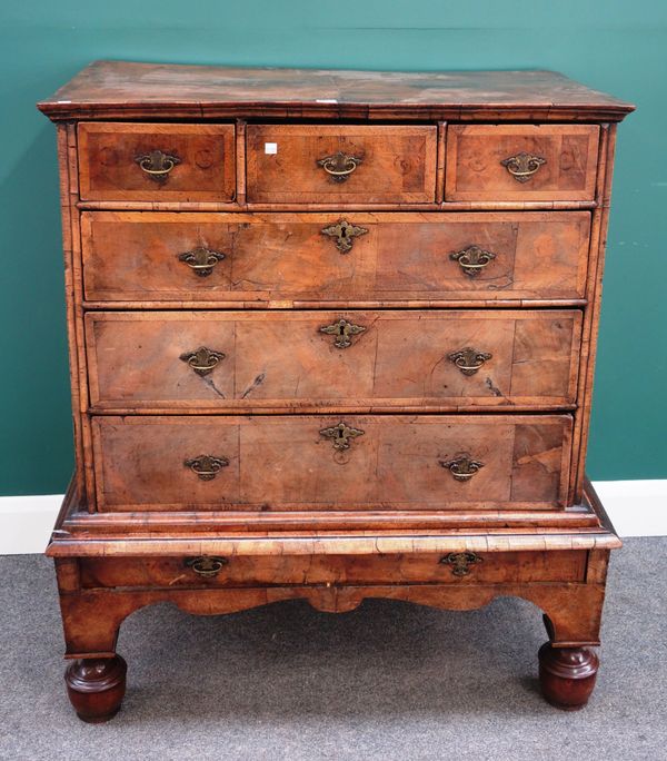 A George I crossbanded walnut chest of three short and three long graduated drawers on stand, with turned supports, 103cm wide x 117cm high.