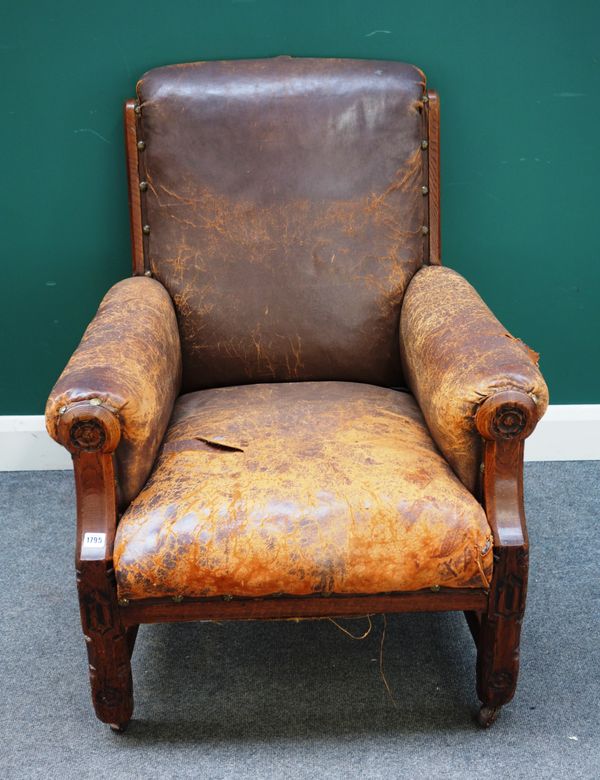 An early Victorian Gothic Revival oak and leather armchair in the manner of AWN Pugin, the back and arms within chamfered frame with floral carved rou