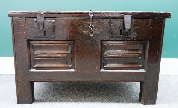 A early 17th century oak coffer/ strong box, with double locking lid over  carved linen fold panels on block supports, 82cm wide  x 35cm deep.