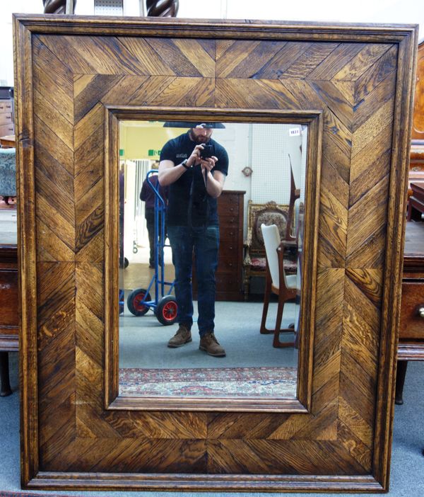 A large oak framed rectangular mirror, the beveled plate within herringbone parquetry, 123cm x 153cm.