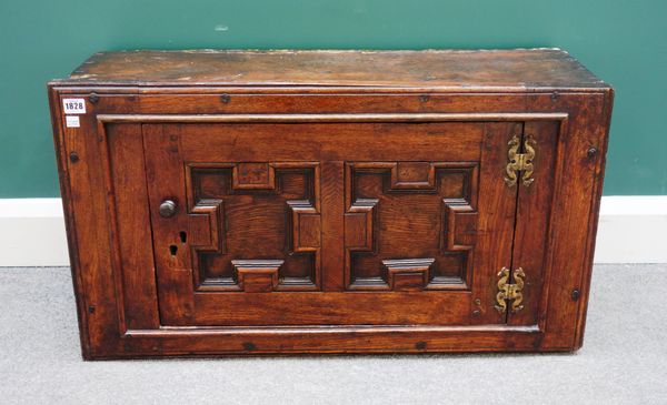 A Charles II hanging single door cupboard with geometric moulding, 86cm wide x 47cm high.