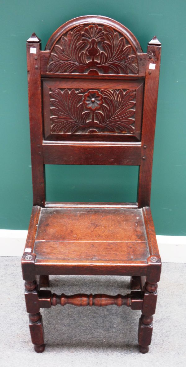 A 17th century Lancashire carved oak panel back single chair, on block and turned supports, 45cm wide x 110cm high.