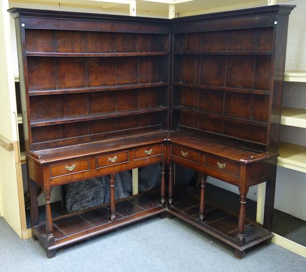 A mid-18th century oak corner dresser/ 'crooked dresser', with enclosed three tier back over five frieze drawers, on baluster turned supports and potb