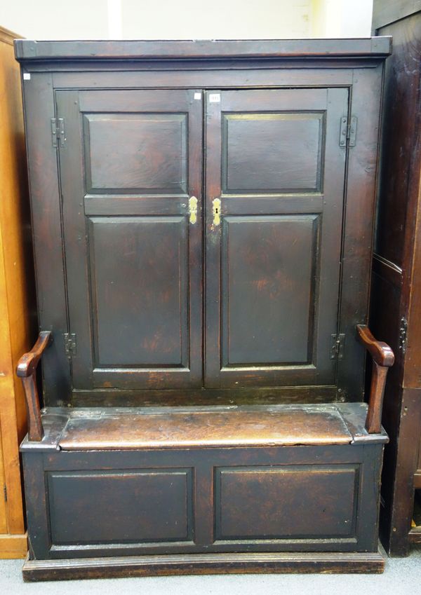 An 18th century Welsh cupboard back oak open arm box seat settle/bacon cupboard, on plinth base, 115cm wide x 172cm high.