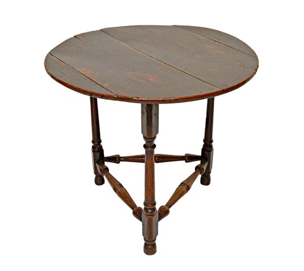 A late 17th century oak cricket table, the four plank circular top on turned supports and stretchers, 74cm wide x 65cm high.   Illustrated