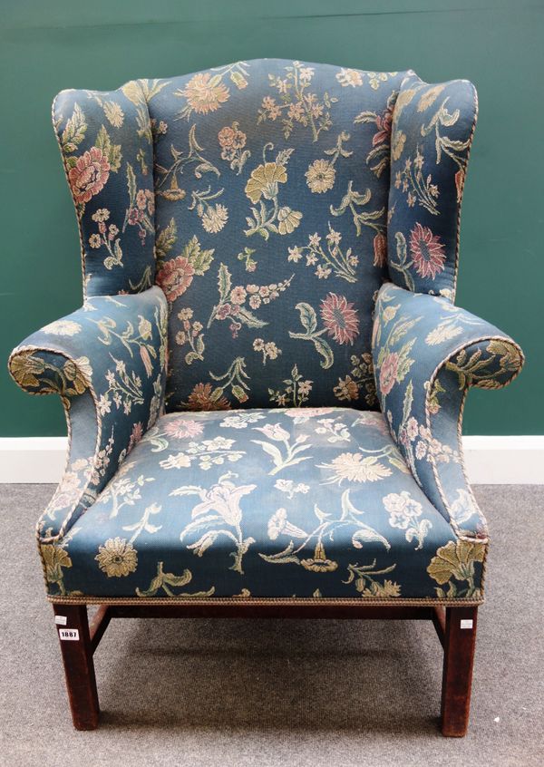 An early 18th century wing back armchair, with roll over arms, on block mahogany supports, 88cm wide x 113cm high.