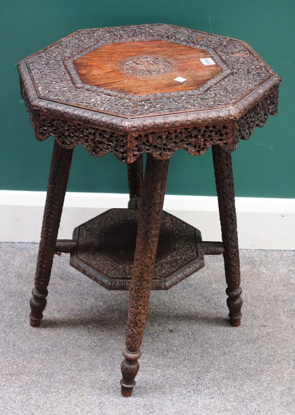 A 19th century Indian carved hardwood octagonal occasional table, with allover floral, figural and animal decoration, on four tapering legs 51cm wide