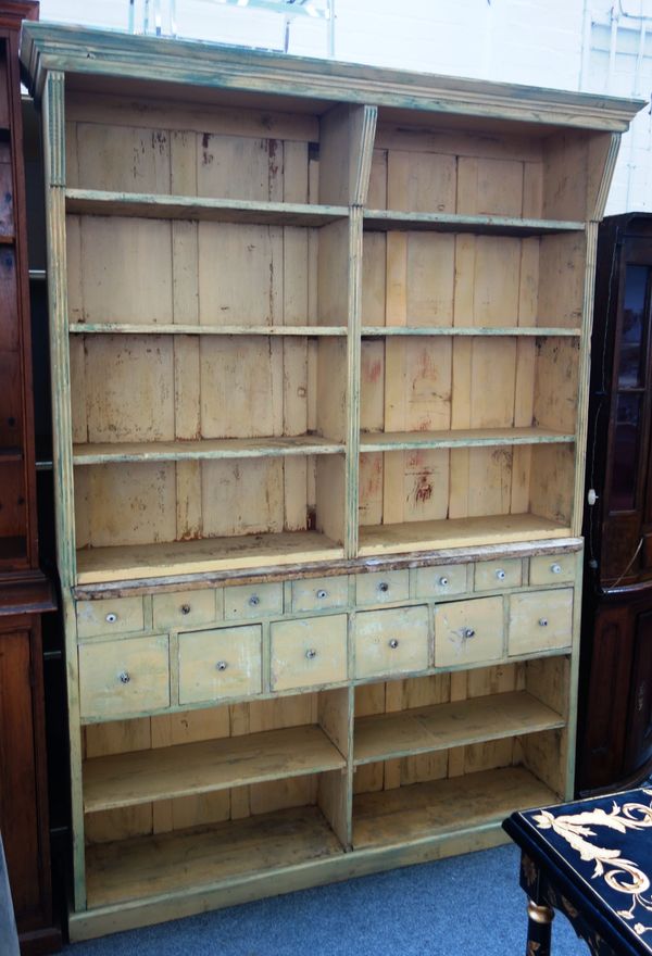 A yellow painted pine dresser, with enclosed rack over fourteen various drawers, 166cm wide x 226cm high.